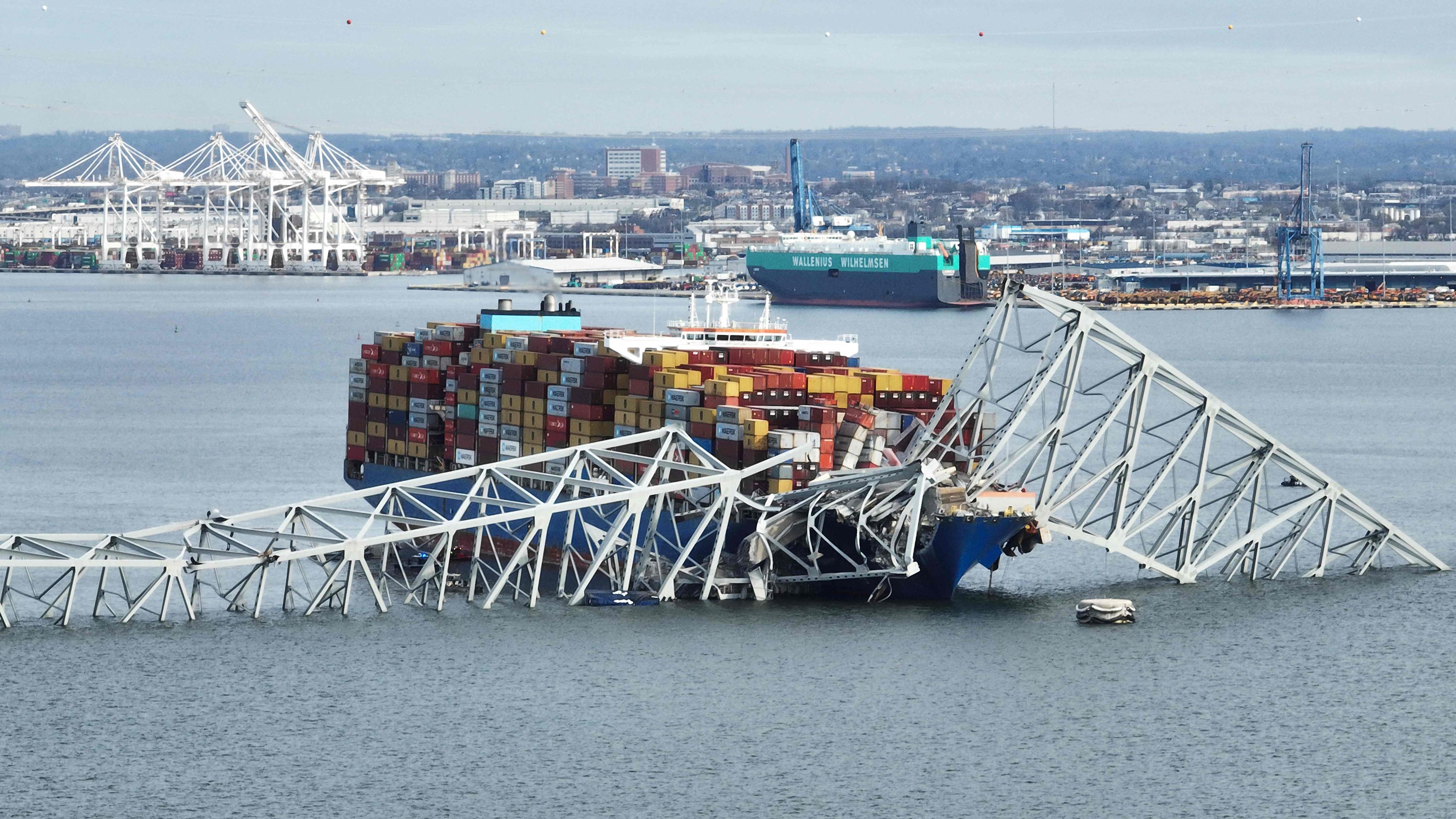 Eine Luftaufnahme zeigt das Containerschiff und Teile der eingestürzten Brücke in Baltimore bei Tag.
