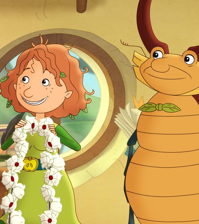 Petronella hält ein Blumenband, das magische Band der Freundschaft, in der Hand mit Hirschkäfer Lucius.