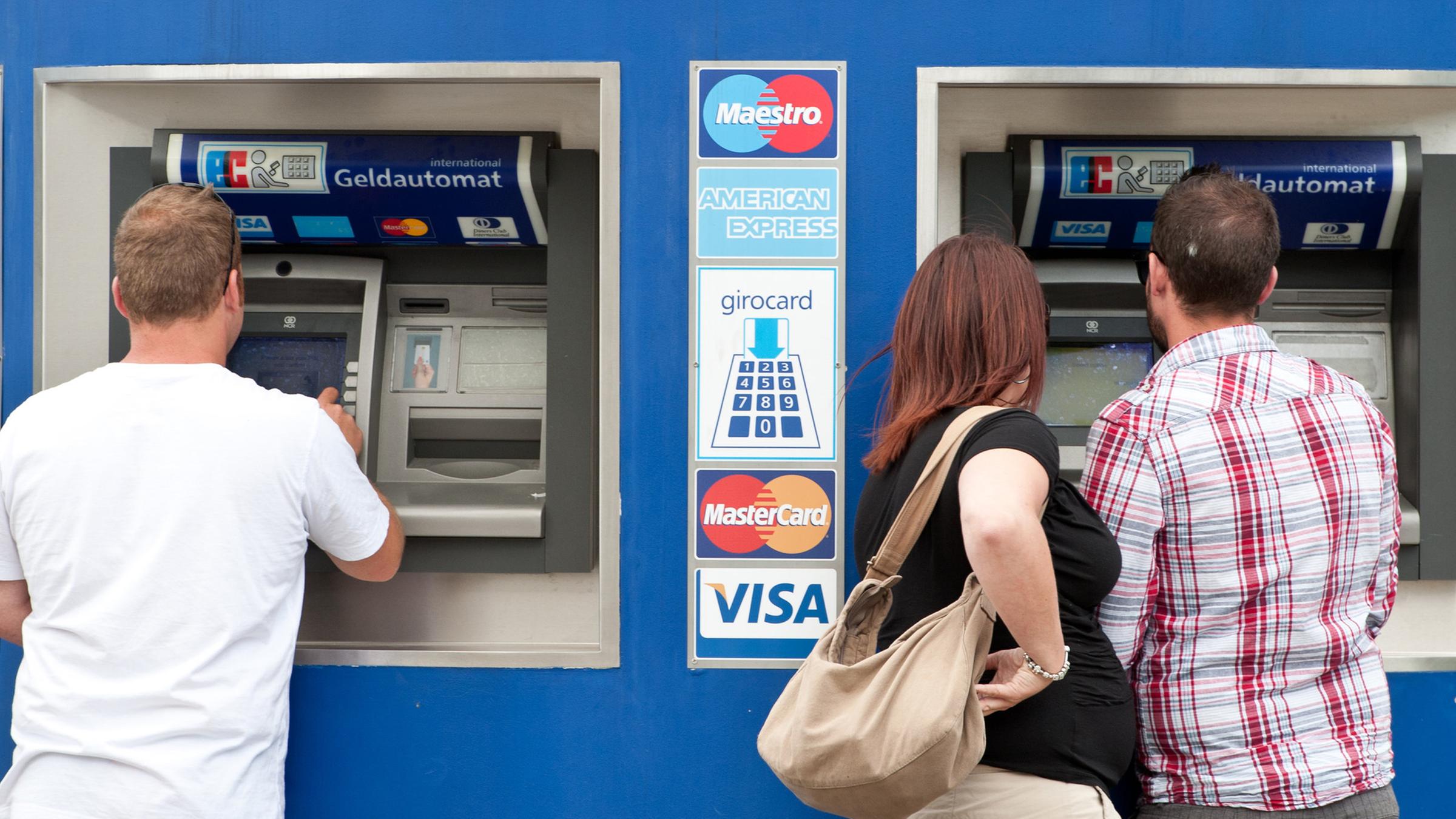 Bankkunden stehen am 23.05.2011 in Berlin an einem Bankautomaten.