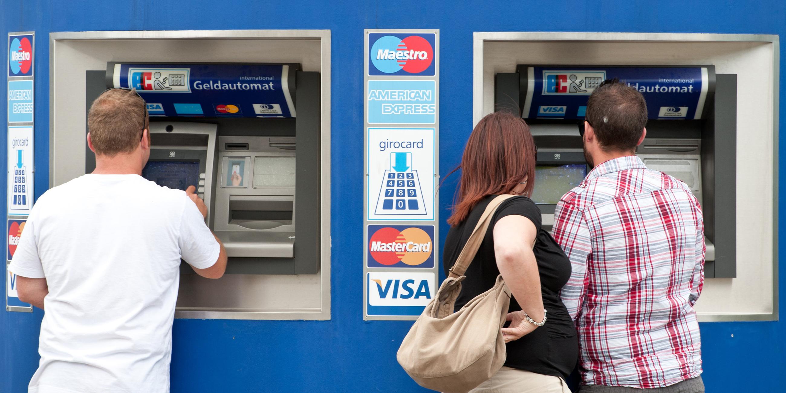 Bankkunden stehen am 23.05.2011 in Berlin an einem Bankautomaten.