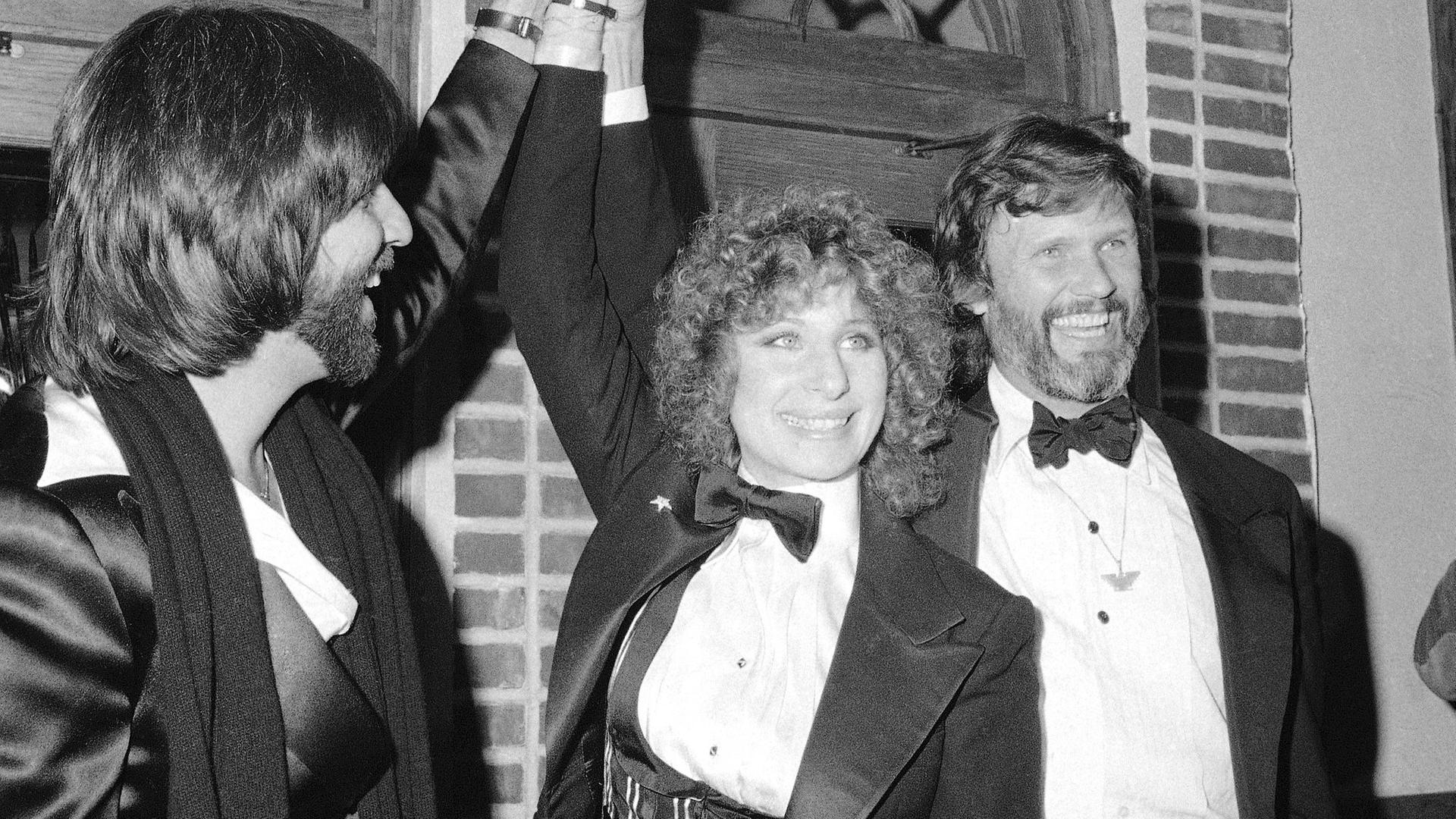 Barbra Streisand 1976 in New York - links von ihr ist Jon Peters und rechts Kris Kristofferson