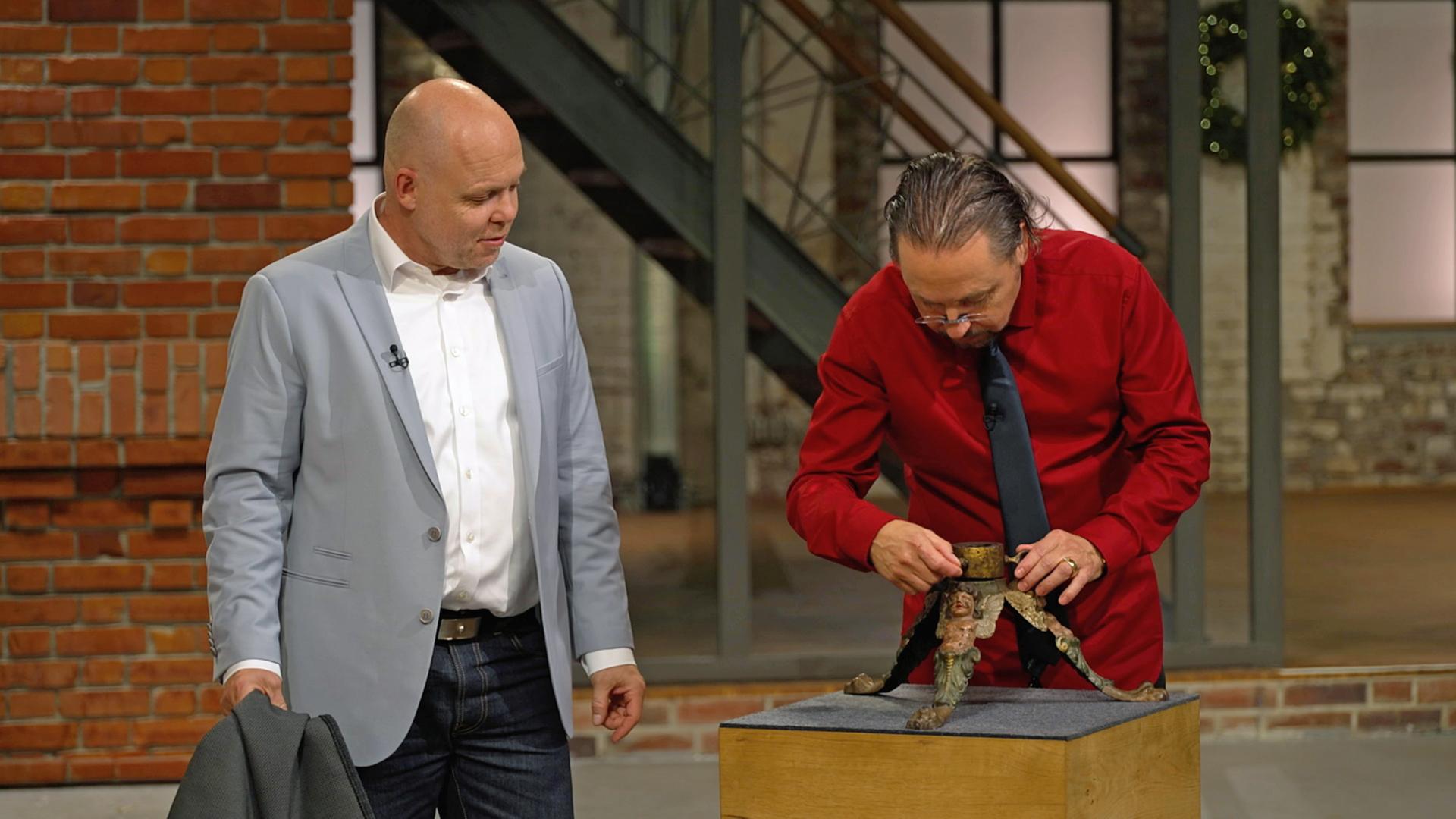 Die Händler Wolfgang Pauritsch und Benjamin Leo Leo betrachten einen Christbaumständer aus der Nähe.