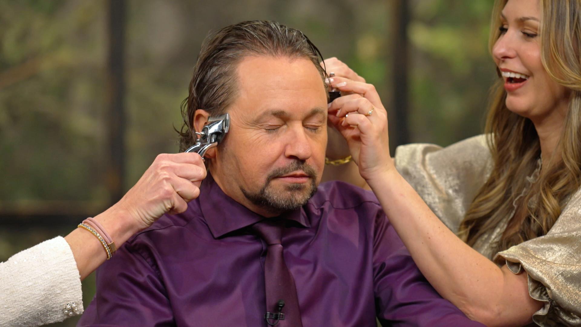 Sarah Schreiber testet eine alte Haarschneidemaschine an Wolfgang Pauritsch.