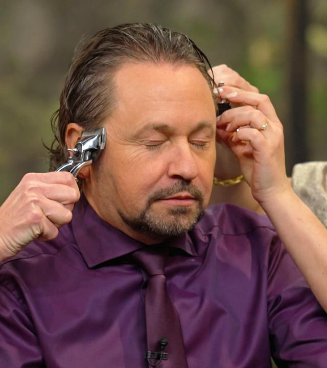Sarah Schreiber testet eine alte Haarschneidemaschine an Wolfgang Pauritsch.