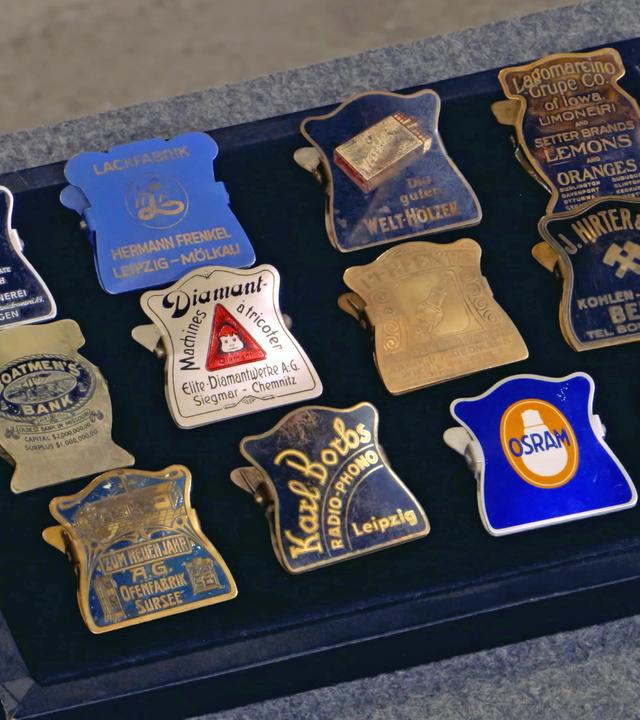 Zwölf Dokumenten-klammern mit Werbung (1910er-1930er Jahre).