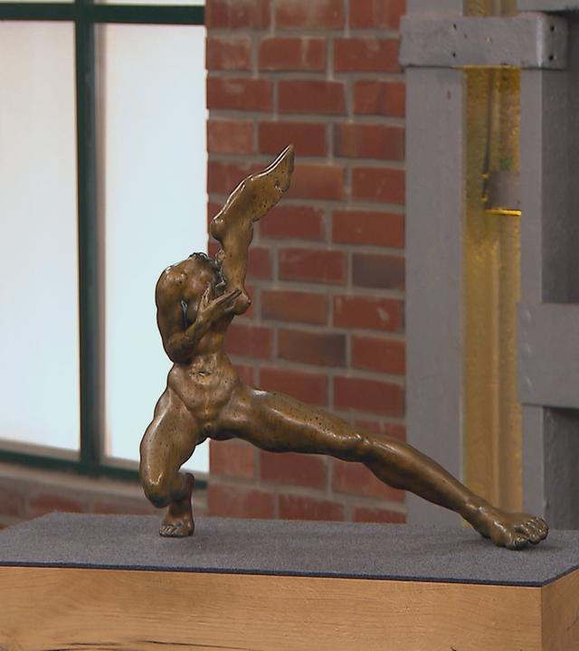 Eine abstrakte Bronzefigur, die einem kopflosen menschlichen Körper ähnelt.