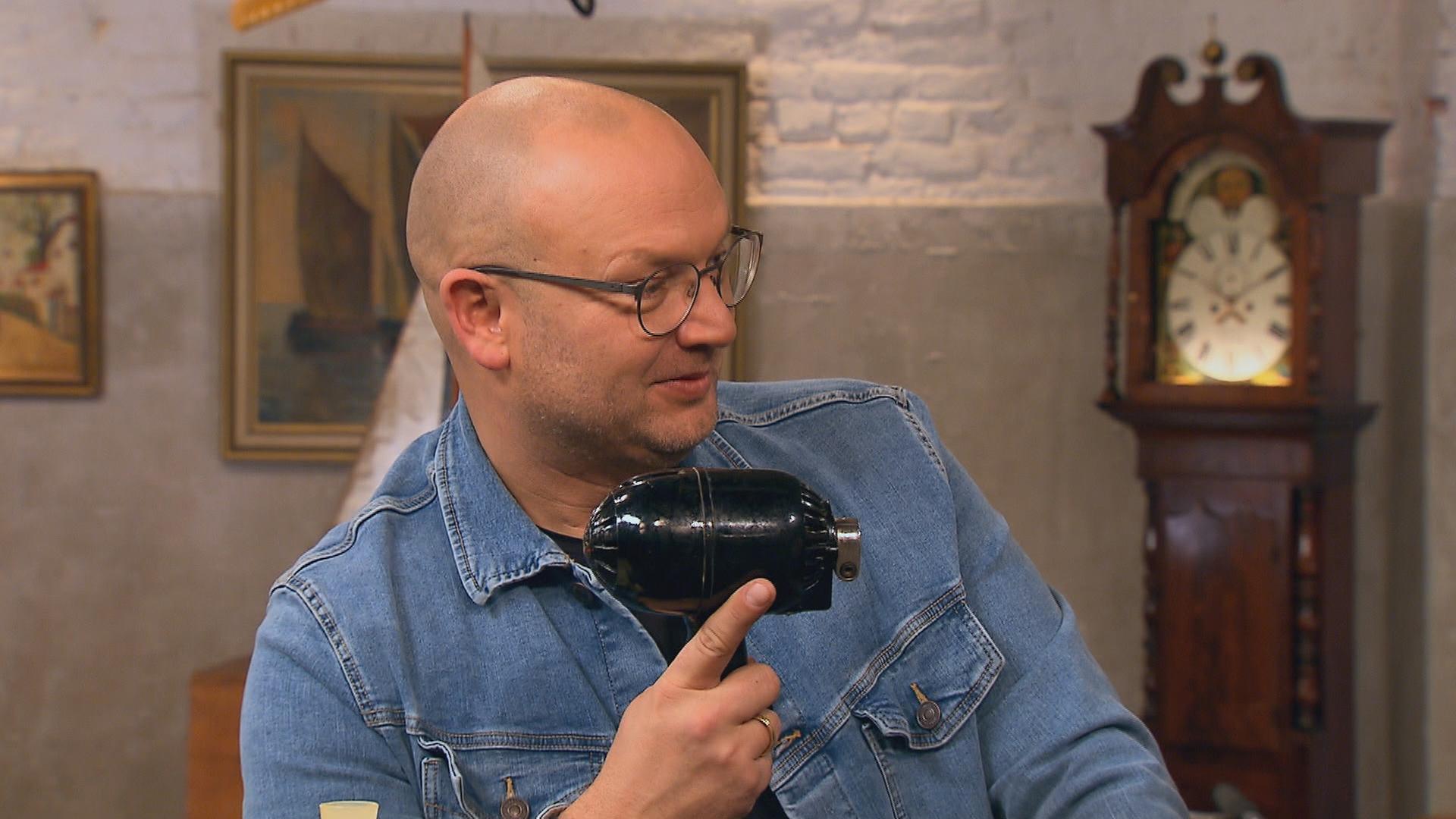 Experte Sven Deutschmanek hält eine Küchenmaschine in der Hand.