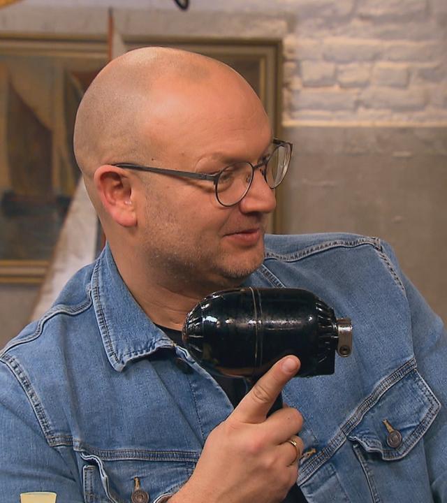 Experte Sven Deutschmanek hält eine Küchenmaschine in der Hand.