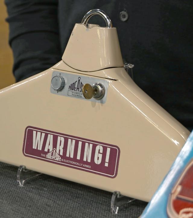 Antiker Kleiderbügel in der Farbe beige mit der Aufschrift "Warning!".