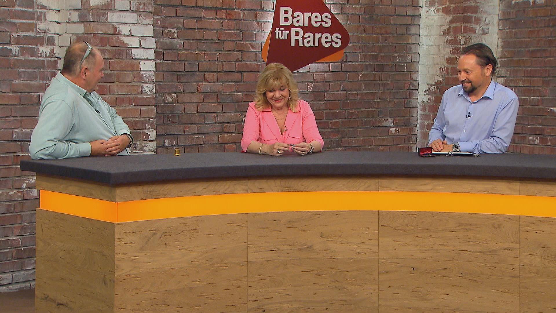 Walter "Waldi" Lehnertz, Elke Velten und Wolfgang Pauritsch sitzen am Händlerpult