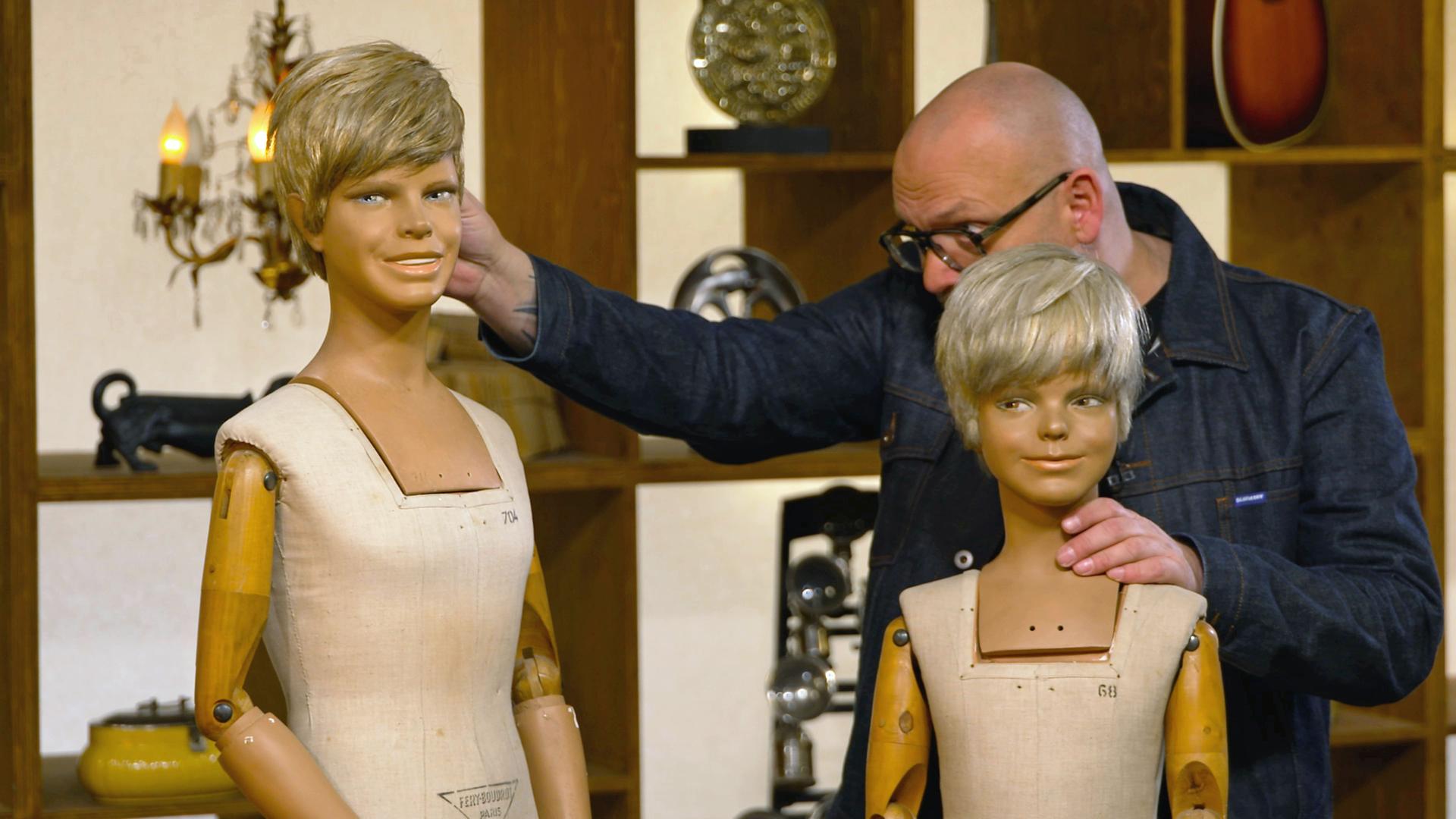 Sven Deutschmanek begutachtet zwei alte Schaufensterpuppen.