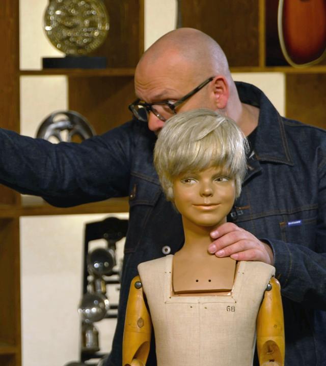 Sven Deutschmanek begutachtet zwei alte Schaufensterpuppen.