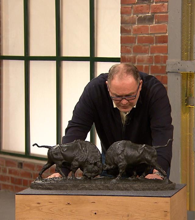 Händler Walter "Waldi" Lehnertz betrachtet eine Bronzefigur