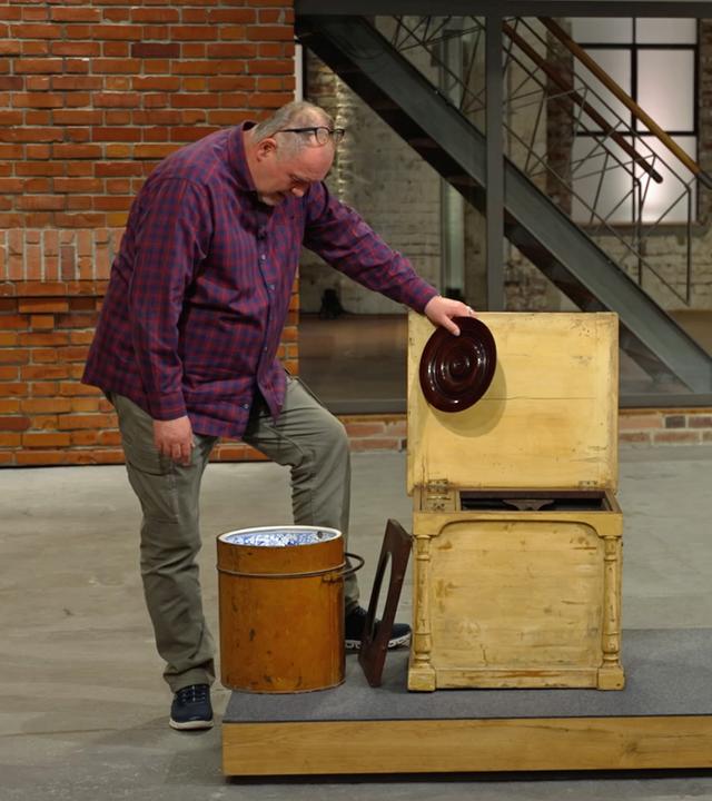 Walter Lehnertz und Elke Velten nehmen eine antike Reisetoilette unter die Lupe.