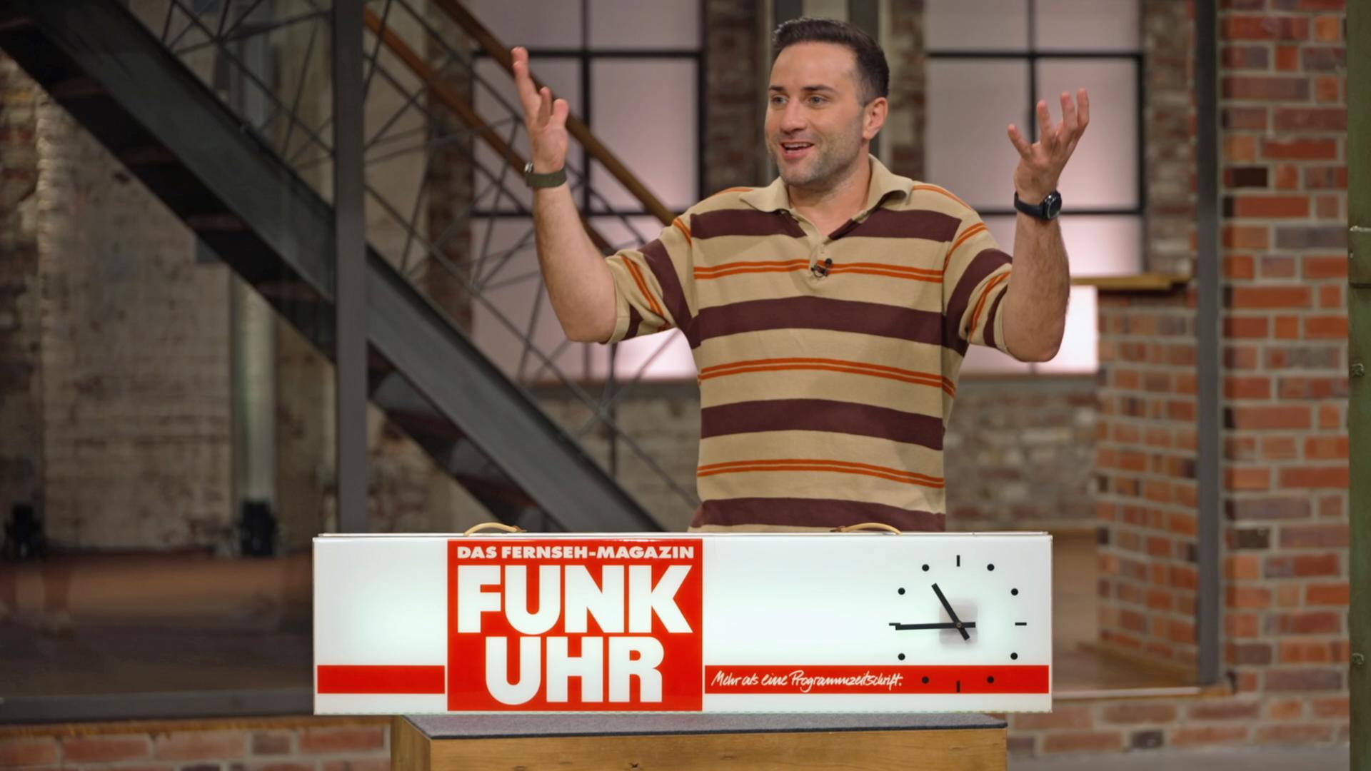 David Suppes mit einer alten Leuchtreklame der Fernsehzeitschrift Funk Uhr.