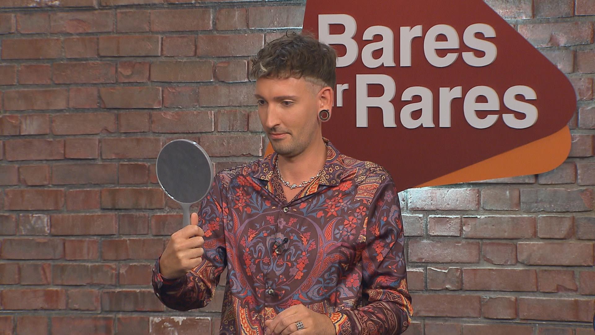 Händler Fabian Kahl betrachtet sich in einem Handspiegel.