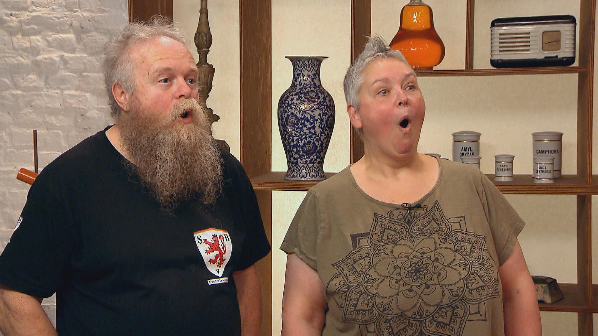 Die Verkäuferin und der Verkäufer eines Armbands machen überraschte Gesichter.