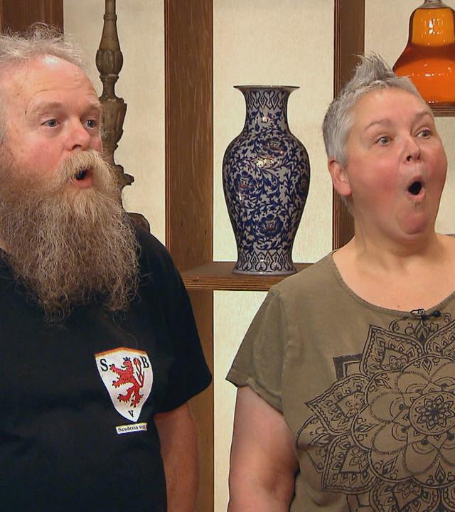 Die Verkäuferin und der Verkäufer eines Armbands machen überraschte Gesichter.