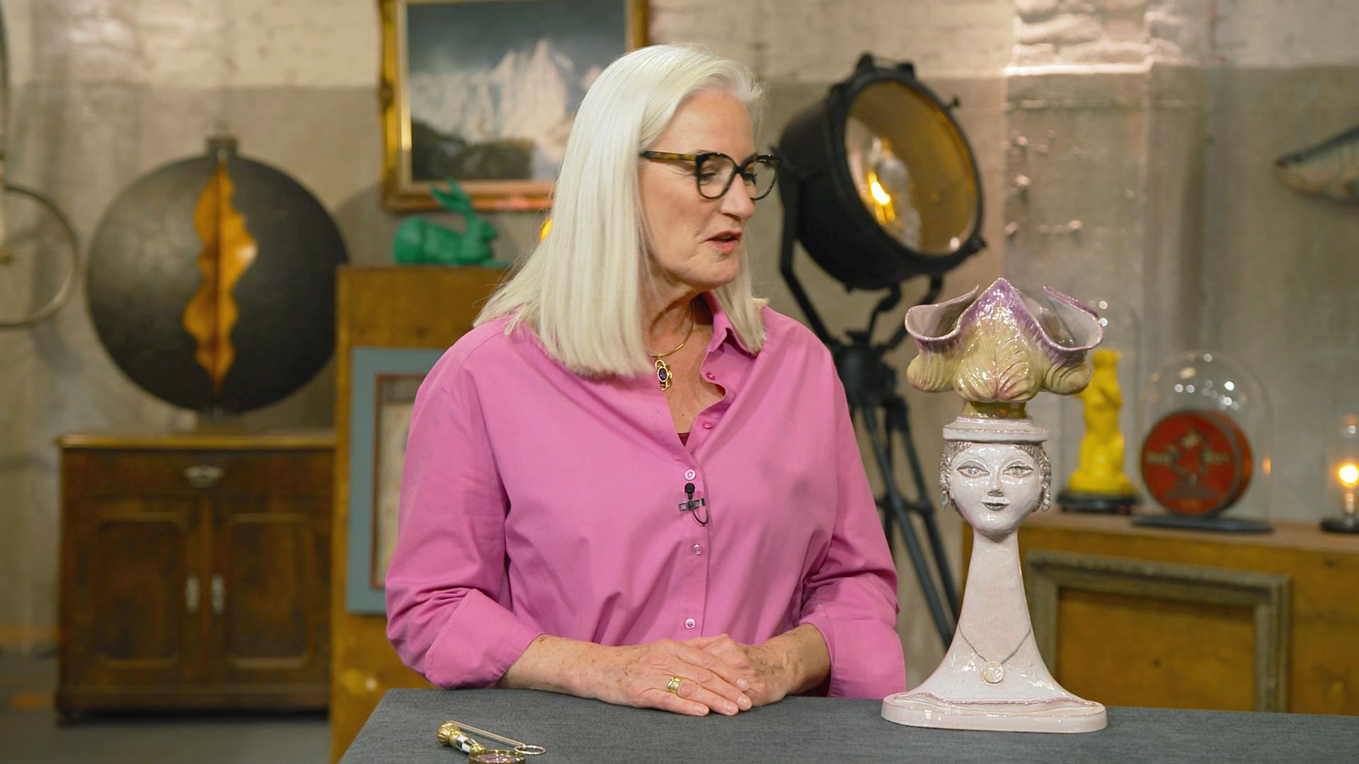 Expertin Dr. Friederike Werner steht neben einer Keramik-Büste mit Salatkopf.