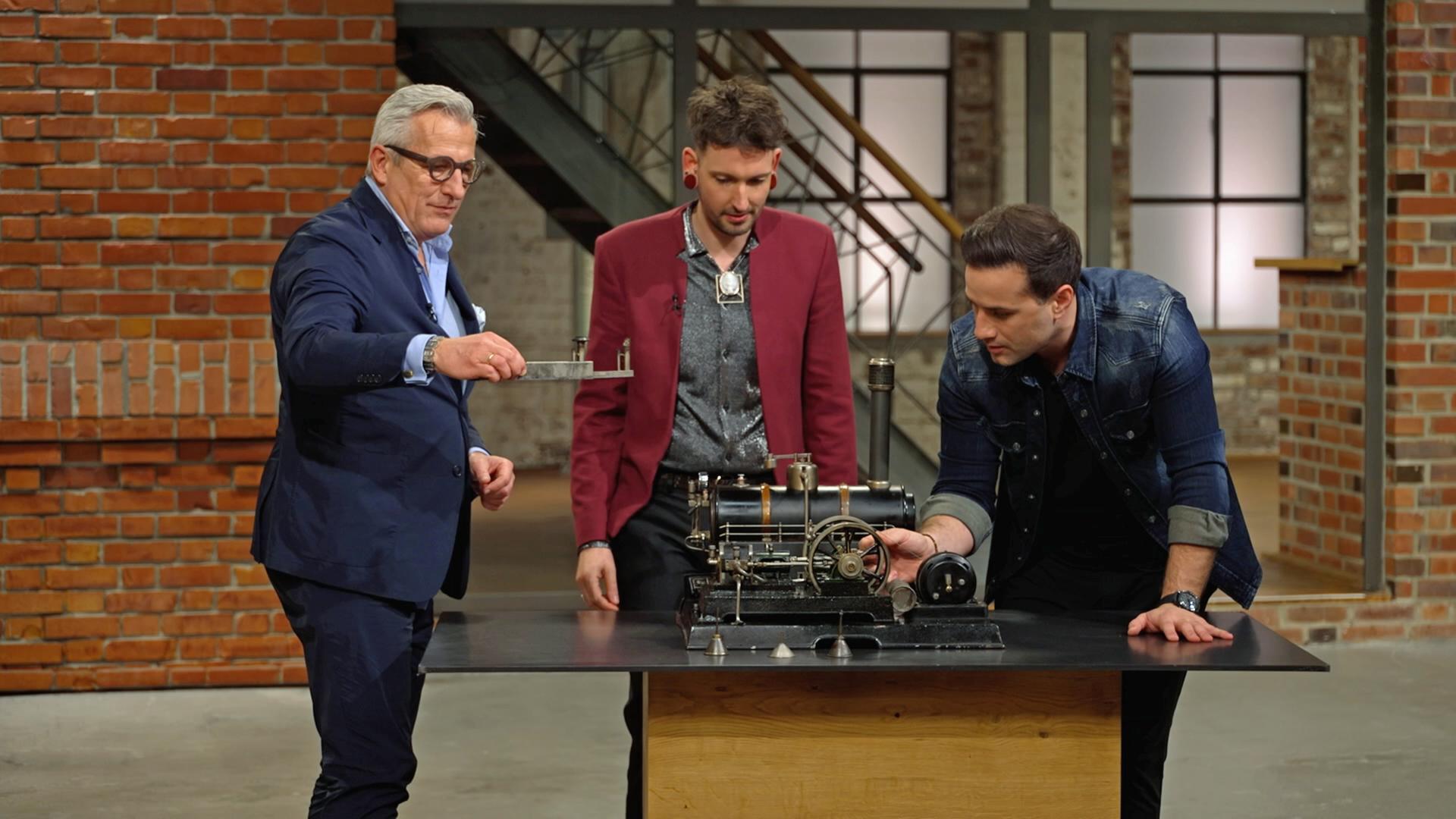 Markus Wildhagen, Fabian Kahl und David Suppes begutachten eine alte Dampfmaschine von Märklin.