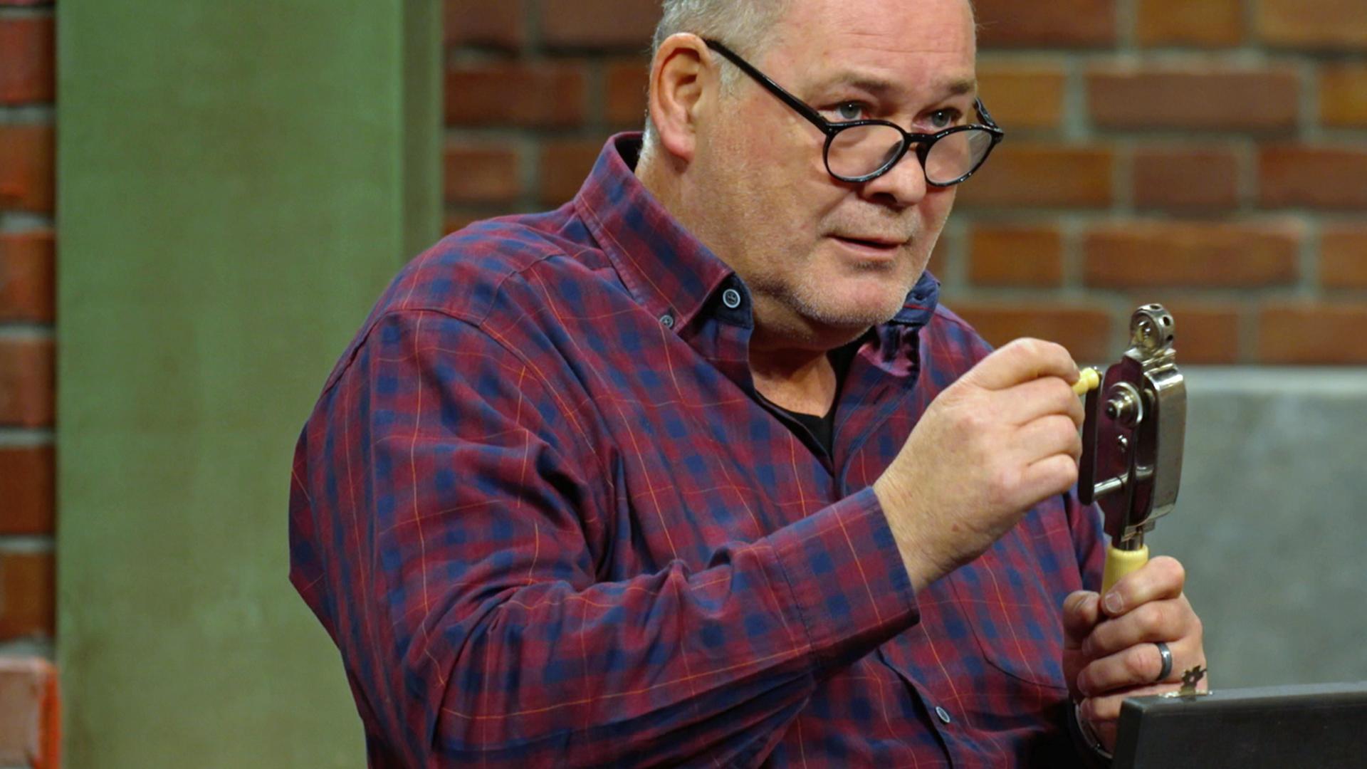 Walter Lehnertz begutachtet ein altes Handkurbelmassagegerät aus dem Jahr 1920.