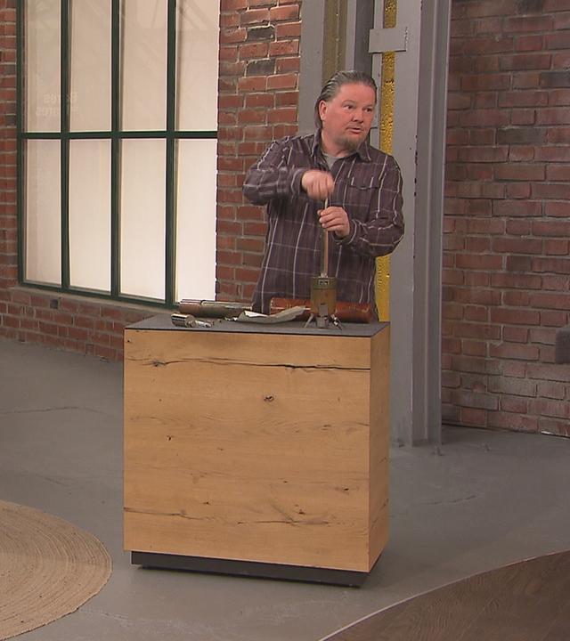 Ein Verkäufer-Ehepaar zeigt im Händlerraum, wie ihr Verkaufsobjekt, ein Hypsometer, zusammengebaut wird.