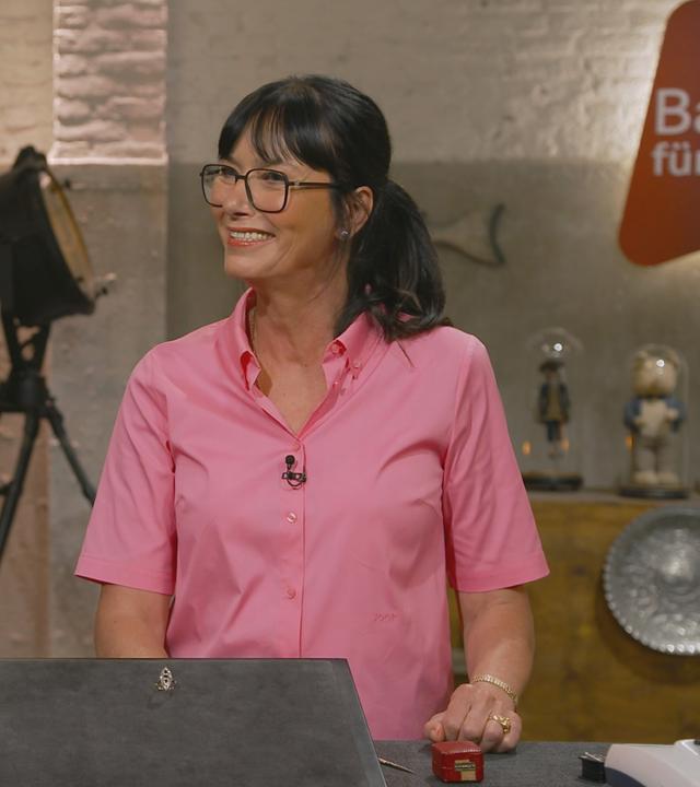 Heide Rezepa-Zabel und eine Verkäuferin stehen nebeneinander und strahlen sich an. Sie sehen sich sehr ähnlich. 