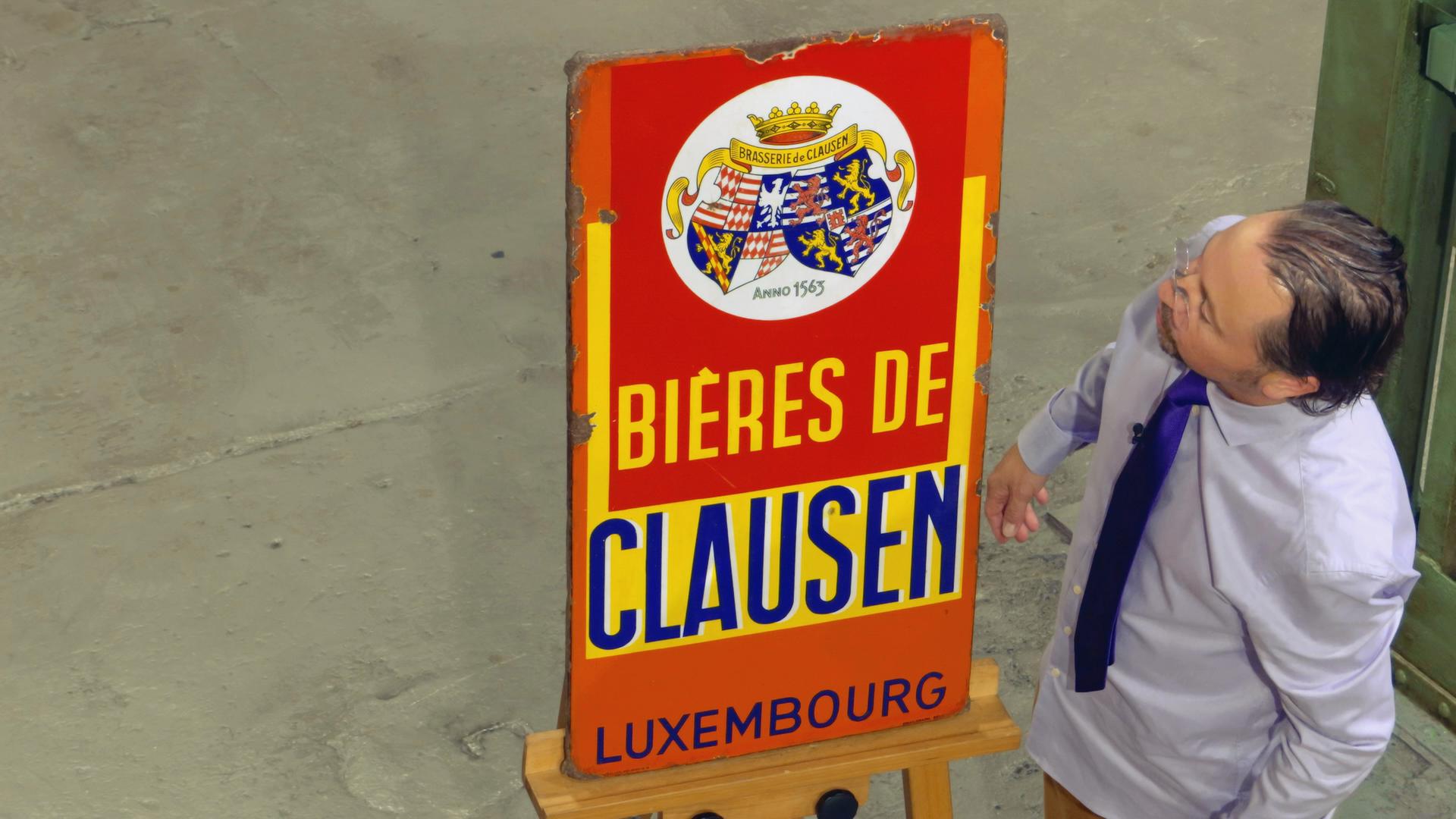 Wolfgang Pauritsch steht neben einem Werbeschild der Biermarke Clausen.