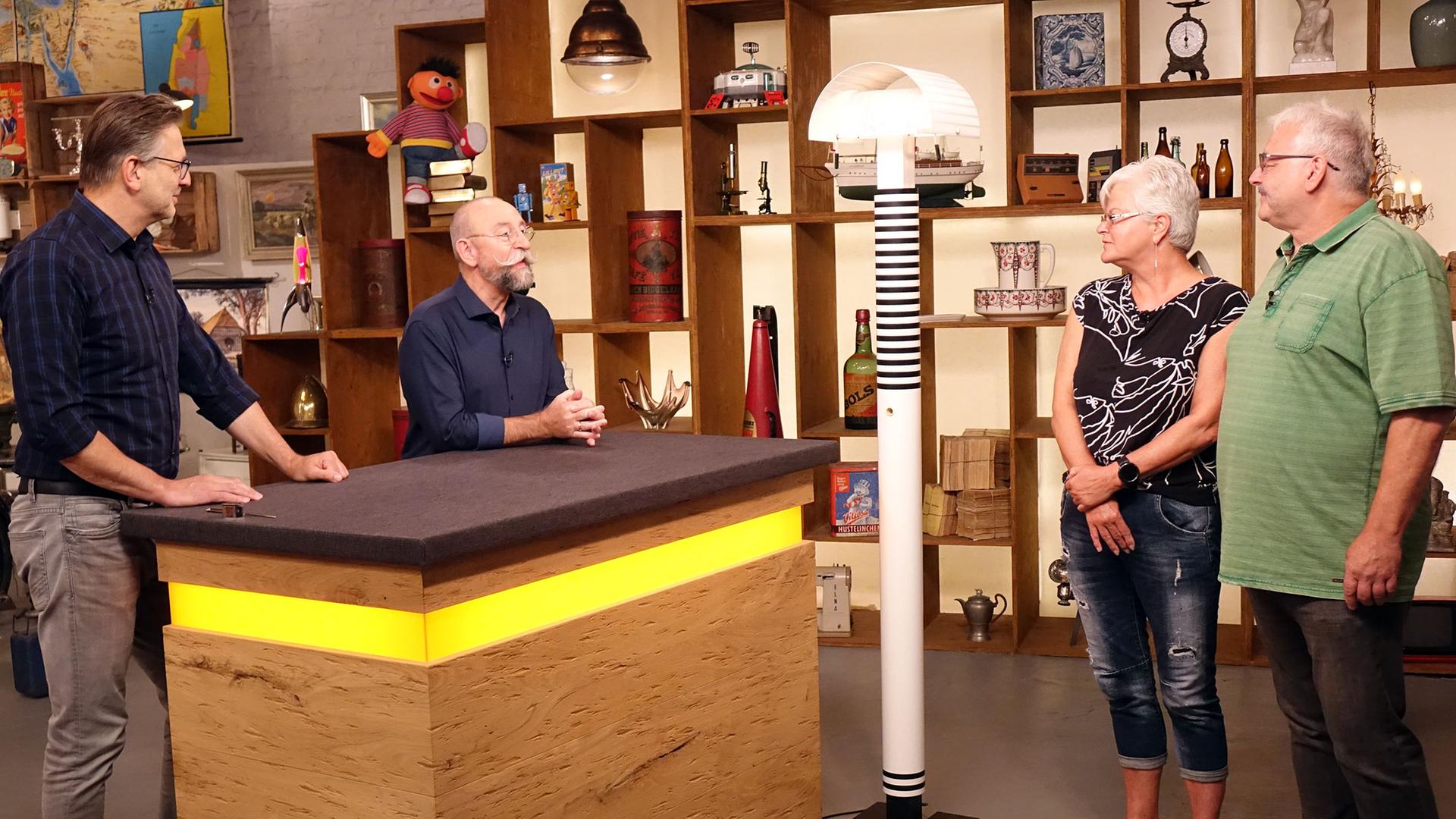 Experte Detlev Kümmel begutachtet eine Stehleuchte von Mario Botta. Neben ihm stehen Horst Lichter und das Verkäufer-Ehepaar.