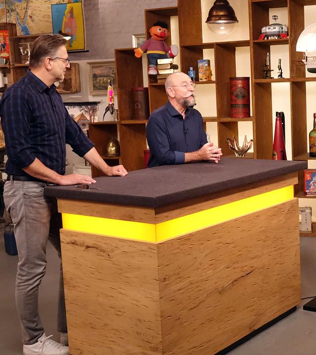 Experte Detlev Kümmel begutachtet eine Stehleuchte von Mario Botta. Neben ihm stehen Horst Lichter und das Verkäufer-Ehepaar.