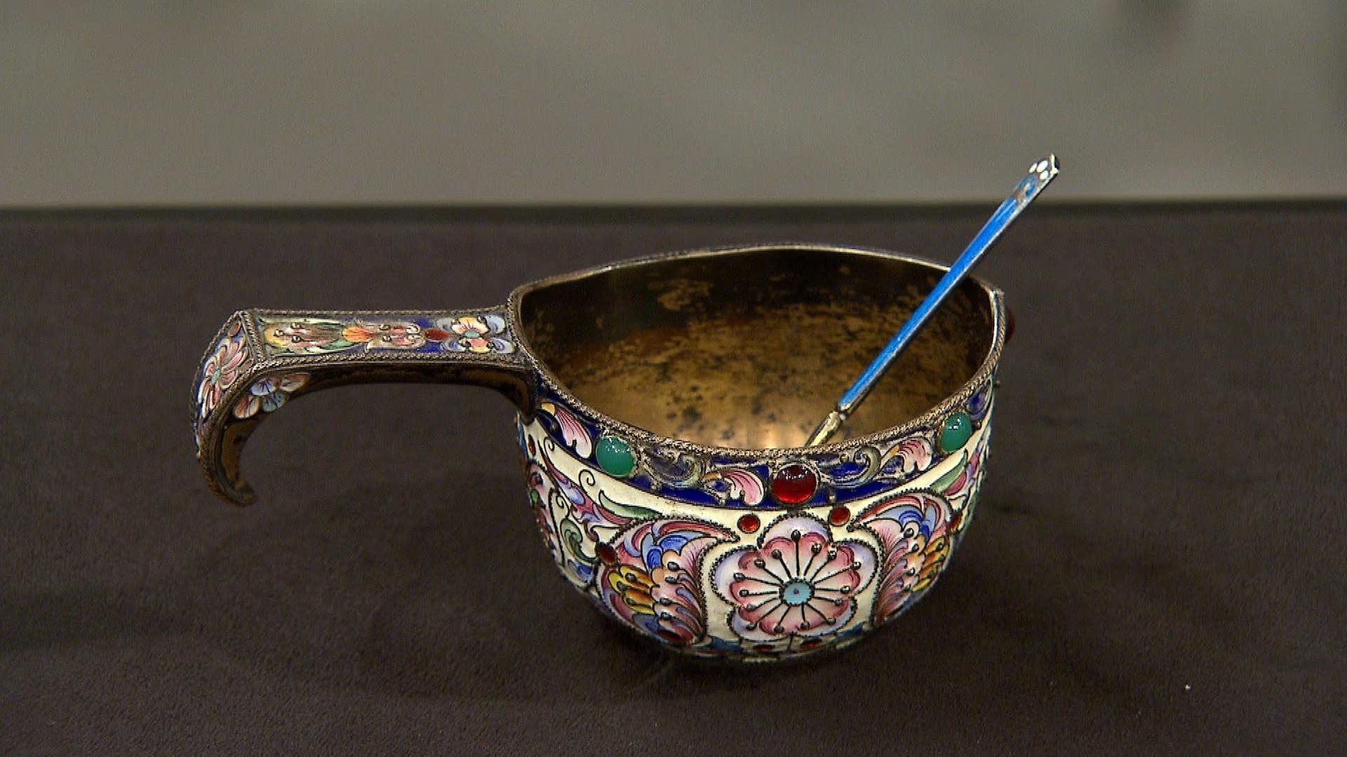 Ein antiker "Kovsh", eine gemusterte Silberschüssel mit einem Löffel mit langem Stiel darin.