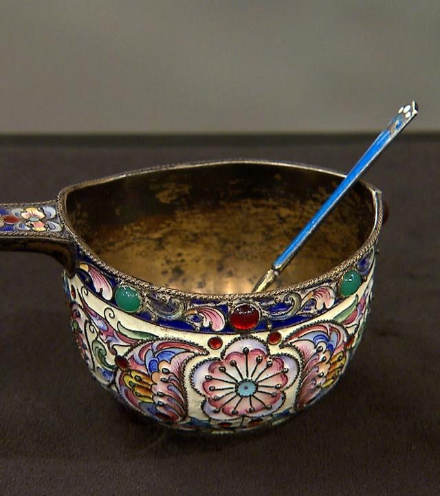 Ein antiker "Kovsh", eine gemusterte Silberschüssel mit einem Löffel mit langem Stiel darin.