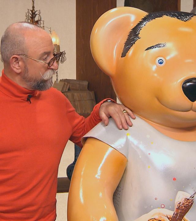 Horst Lichter steht neben einer Bärenfigur.