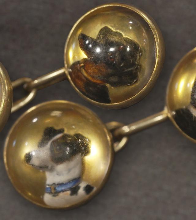 Antike Manschettenknöpfe mit unterschiedlichen Hunderassen verziert.