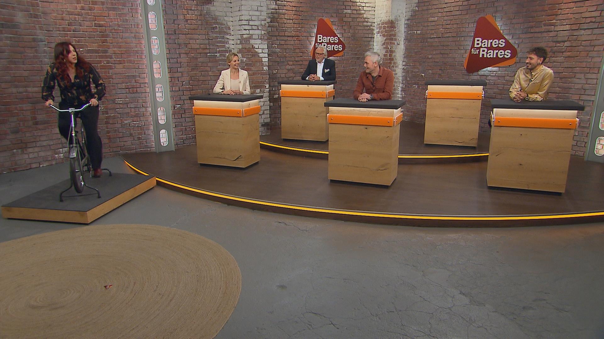 Händlerin Esther Ollick testet ein Trimm-Dich-Rad aus den 1970er Jahren im Händlerraum