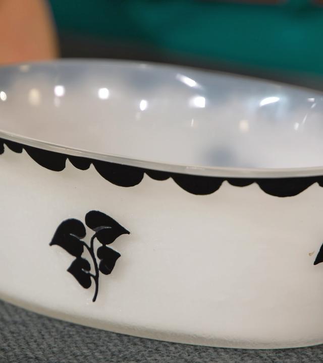 Weißes Glasschälchen mit schwarzen Verzierungen.