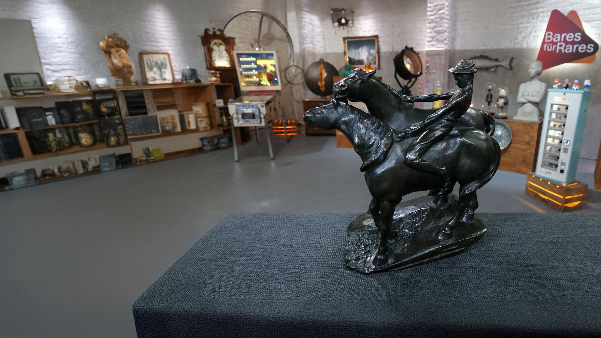 Eine Bronzeskulptur von Leonhard Zeiher zeigt zwei galoppierende Pferde und einen Reiter