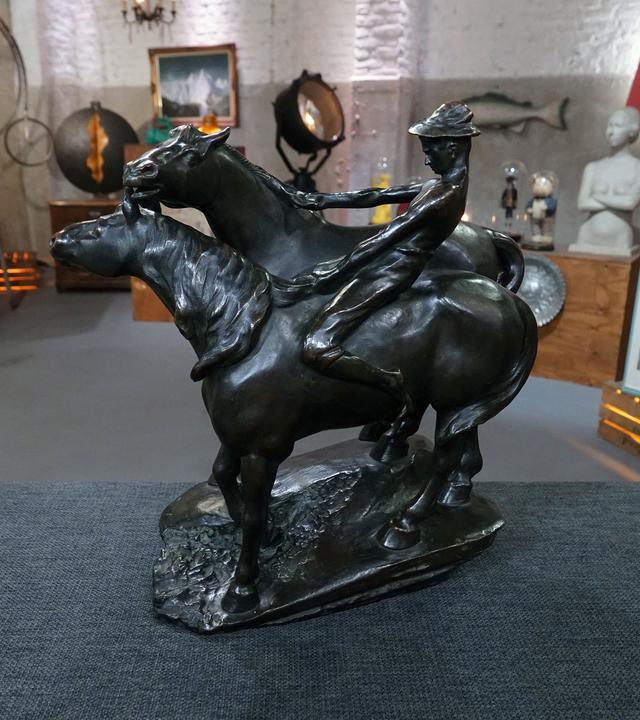 Eine Bronzeskulptur von Leonhard Zeiher zeigt zwei galoppierende Pferde und einen Reiter