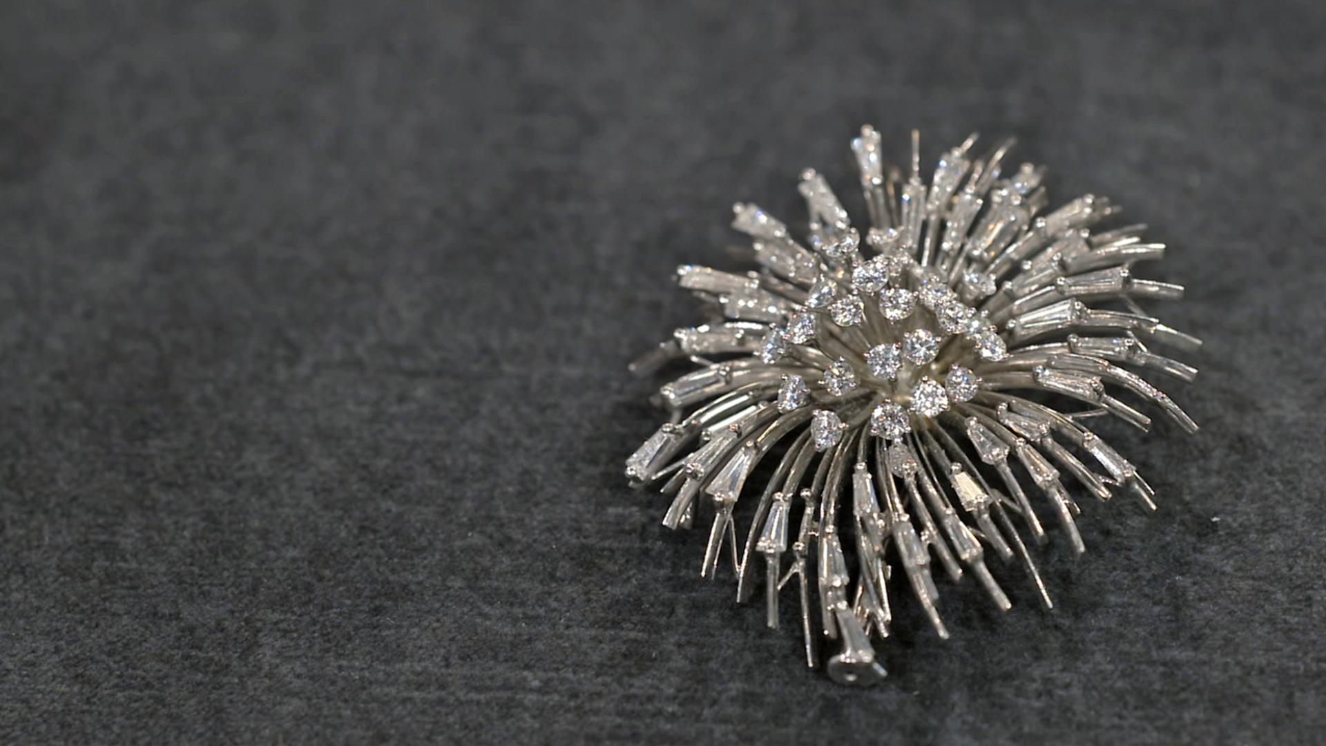 Eine Brosche, die aussieht wie ein explodierendes Feuerwerk.