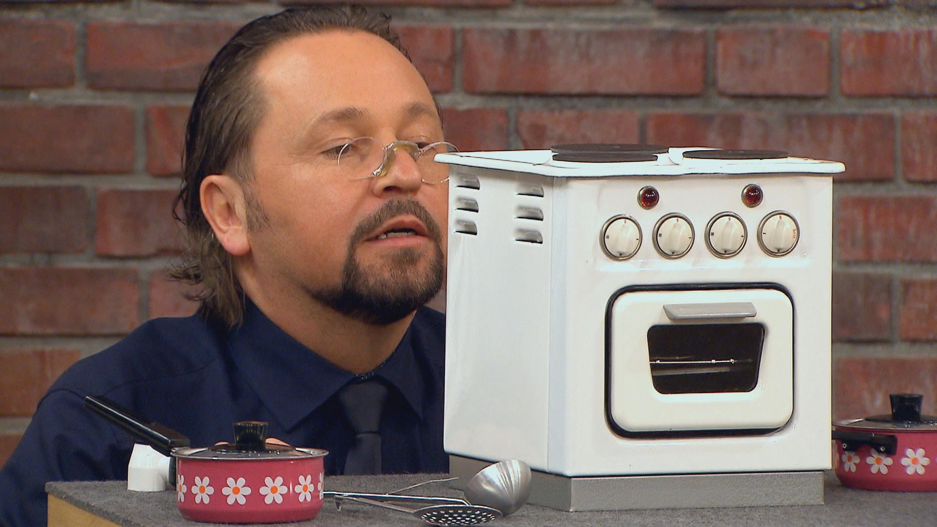 Händler Wolfgang Pauritsch mustert einen Spielzeug-Elektroherd aus den 60er Jahren.