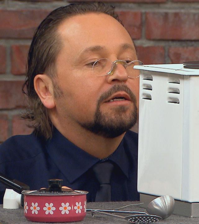 Händler Wolfgang Pauritsch mustert einen Spielzeug-Elektroherd aus den 60er Jahren.