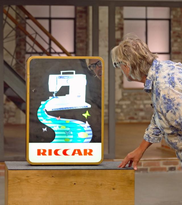 Benjamin Leo Leo und Jos van Katwijk begutachten ein altes Leuchtreklameschild für eine Riccar-Nähmaschine.