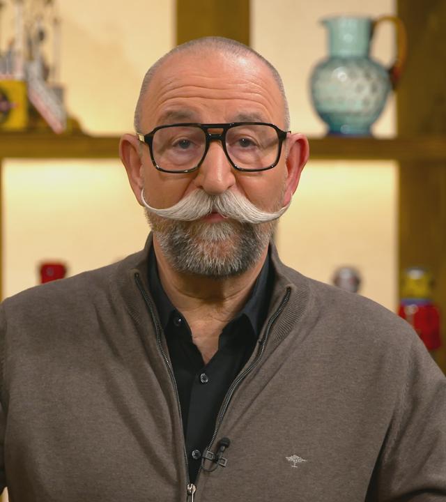 Close-Up von Horst Lichter, der die eckige, schwarze Brille von Sven Deutschmanek aufgesetzt hat.