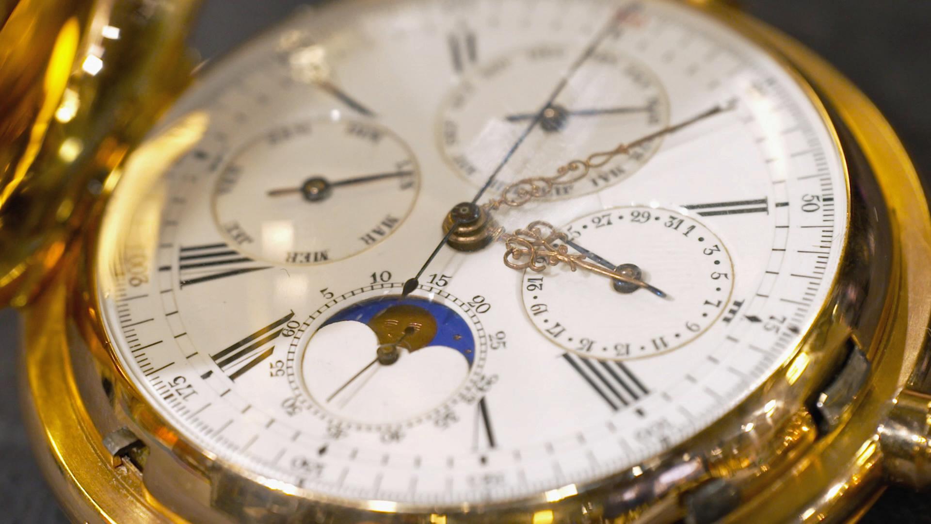 Schweizer Taschenuhr mit goldenem Gehäuse und weißem Ziffernblatt.