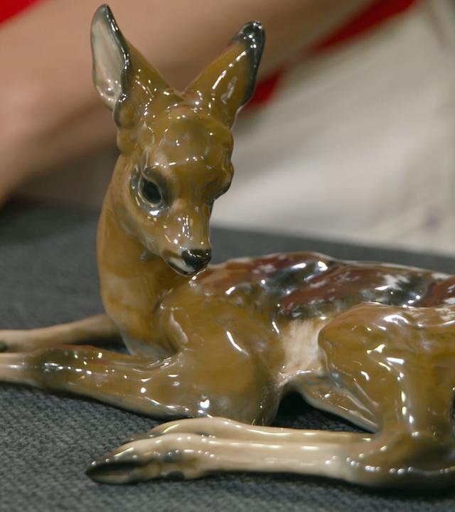 Ein liegendes Rehkitz aus Porzellan.