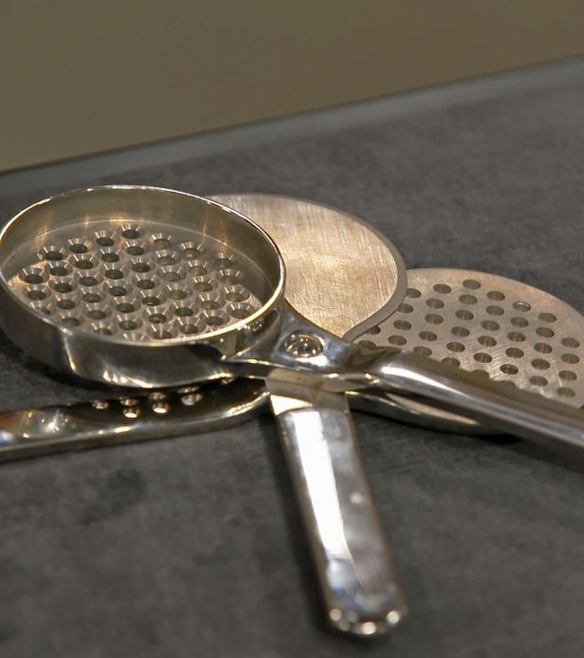 Dreiteiliger Kornteiler mit zwei Sieblöffeln.