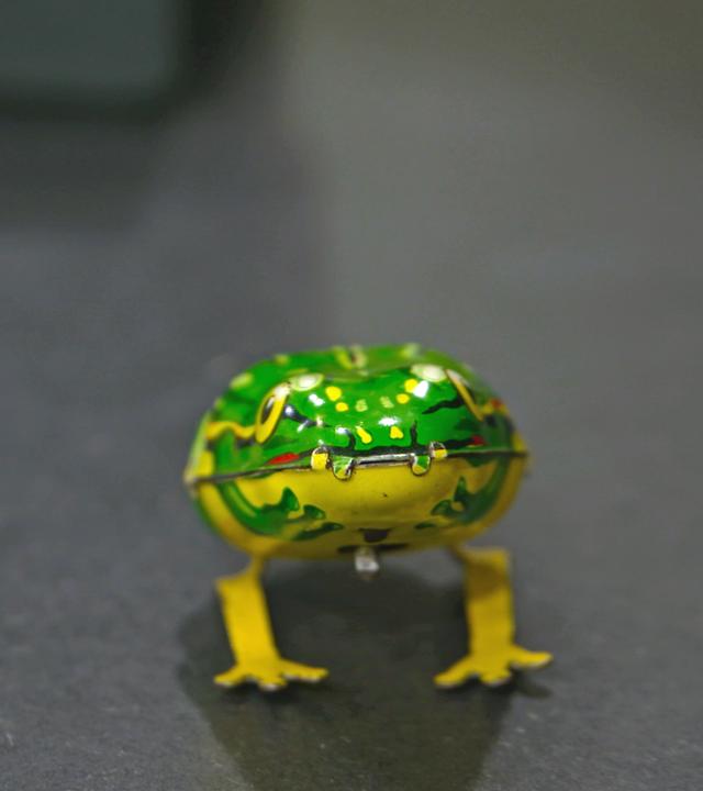 Zwei Blechspielzeugfiguren: Eine Wackel-Ente und ein Hüpf-Frosch