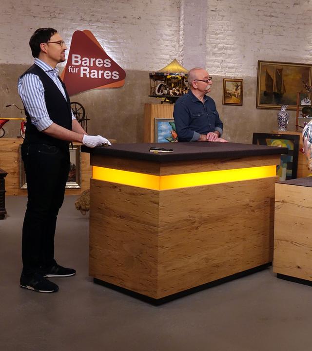 Expertise von Colmar Schulte-Goltz. Der Experte begutachtet einen Leuchtenfuß von Sèvres.