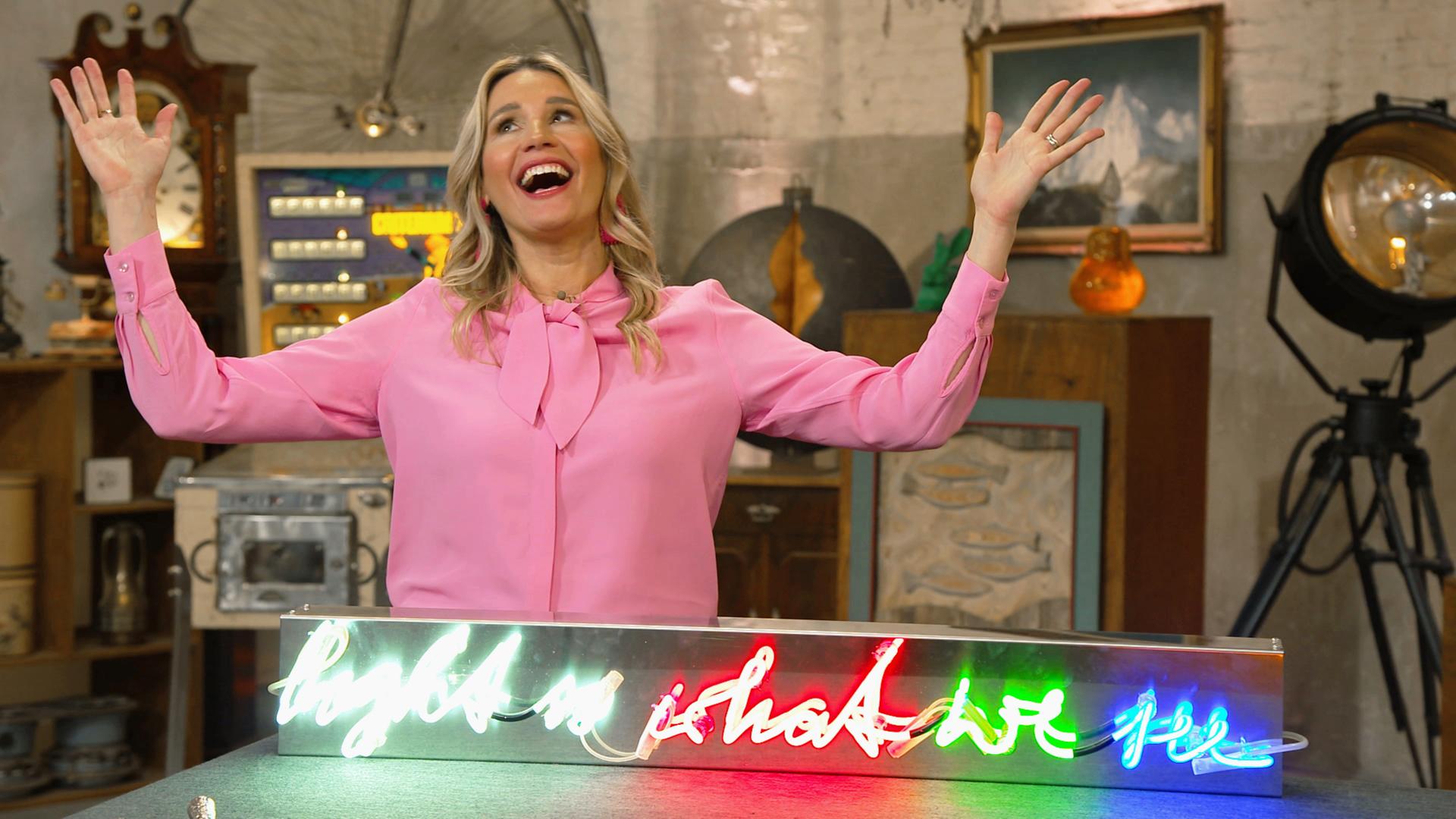 Expertin Bianca Berding mit einem Neon-Schriftzug der Künstlerin Brigitte Kowanz