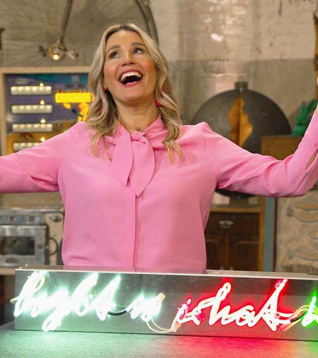 Expertin Bianca Berding mit einem Neon-Schriftzug der Künstlerin Brigitte Kowanz